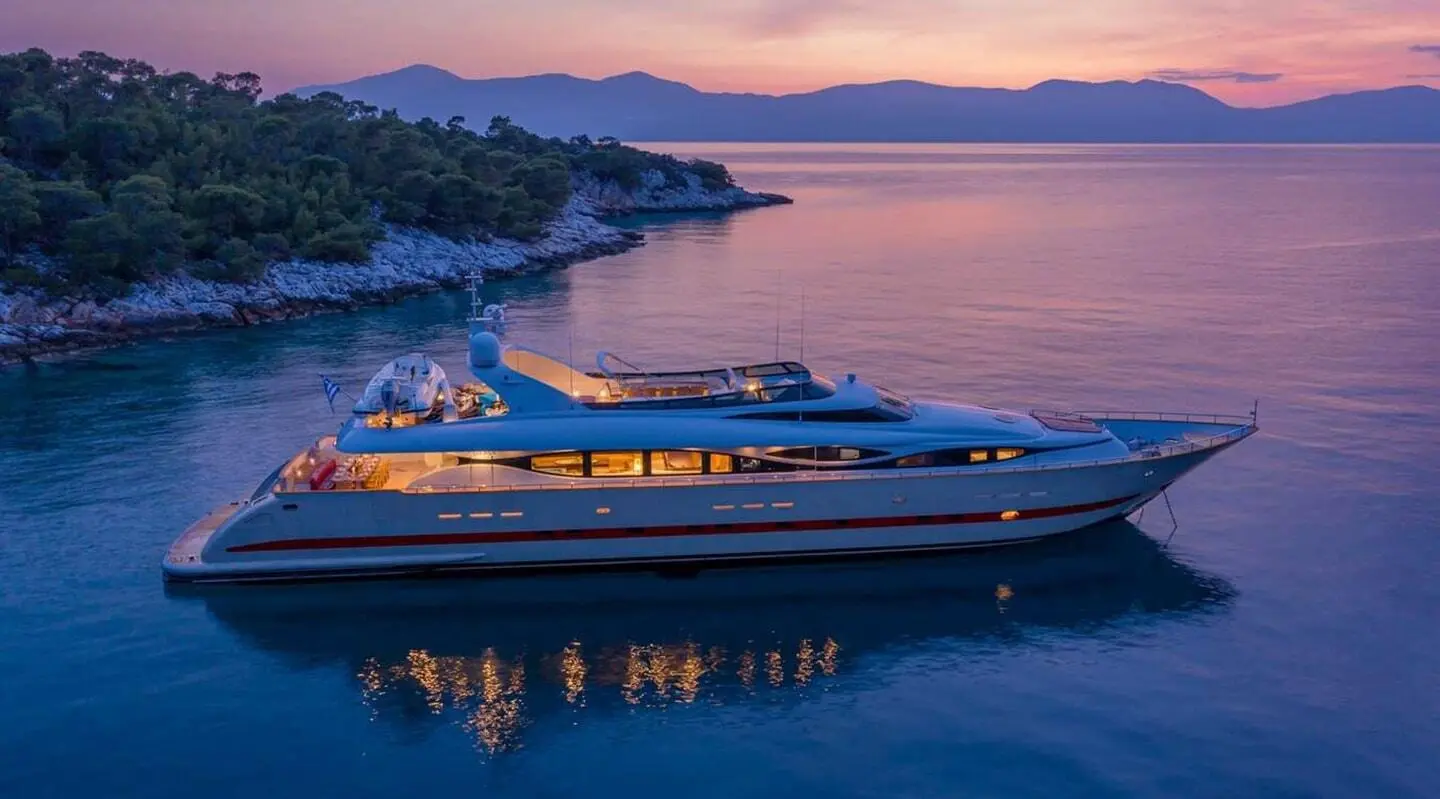 Sunset over calm sea with a sleek yacht named Glaros docked nearby