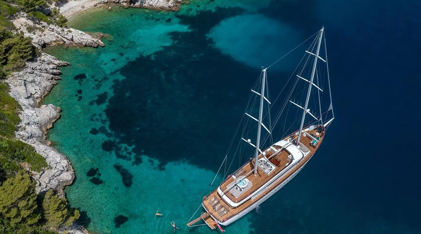 Love Story yacht anchored near turquoise waters with a wooden deck