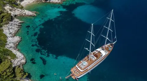 Love Story yacht anchored near turquoise waters with a wooden deck