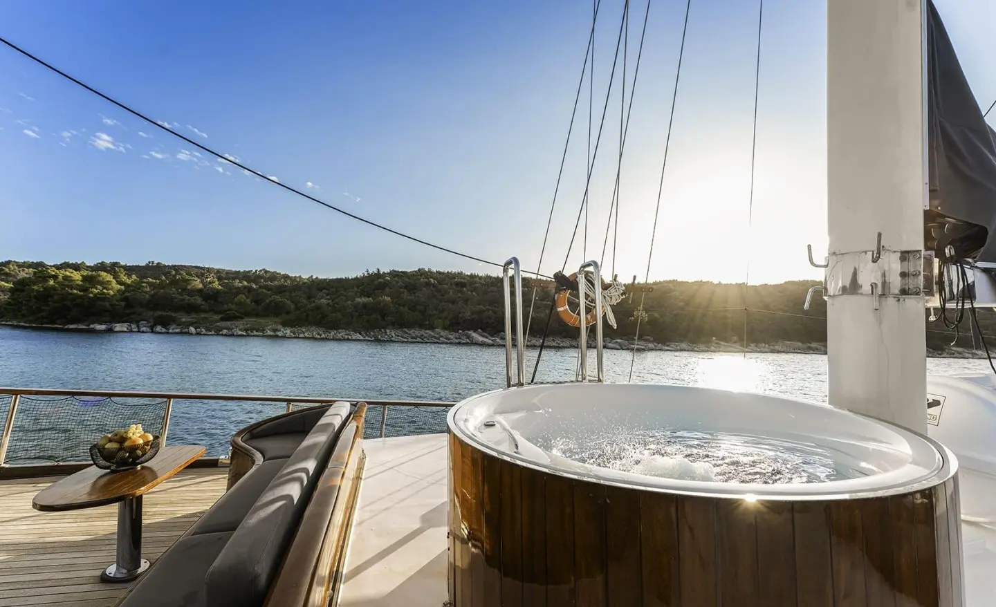 Luxurious yacht deck with a large tub, seating area and sea view