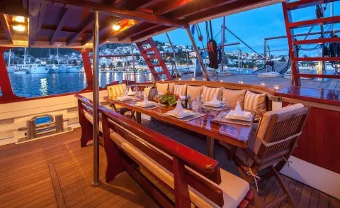 Dining area on aft deck of Romanca gulet with table set under shade