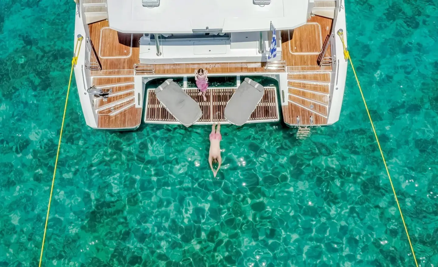 Top view of yacht D2 at anchor with teak deck and clear turquoise water