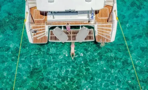 Top view of yacht D2 at anchor with teak deck and clear turquoise water