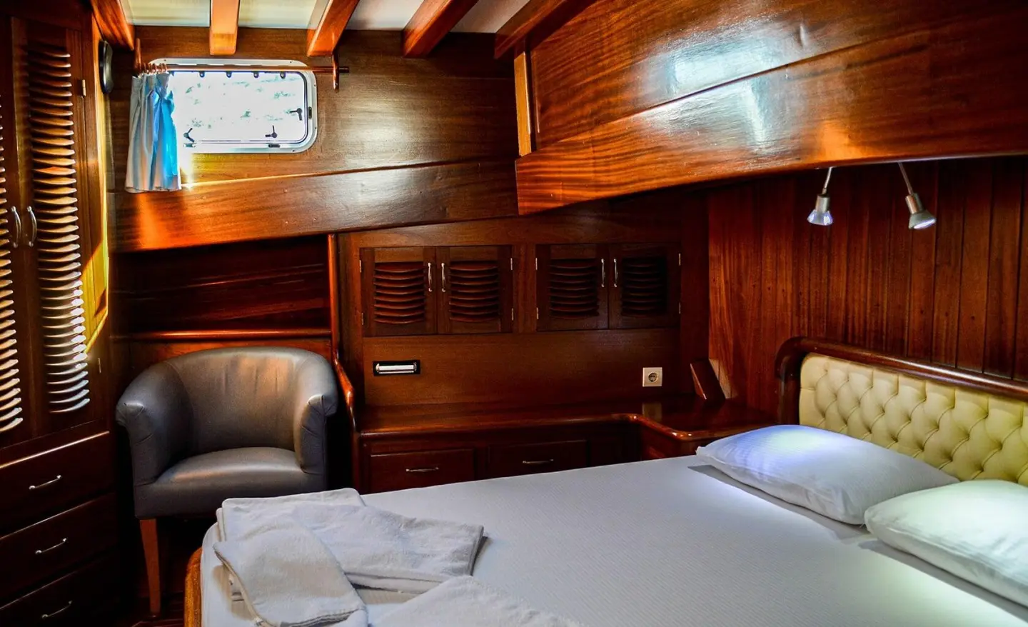 Interior of Enderim A yacht cabin with wood paneling and bed