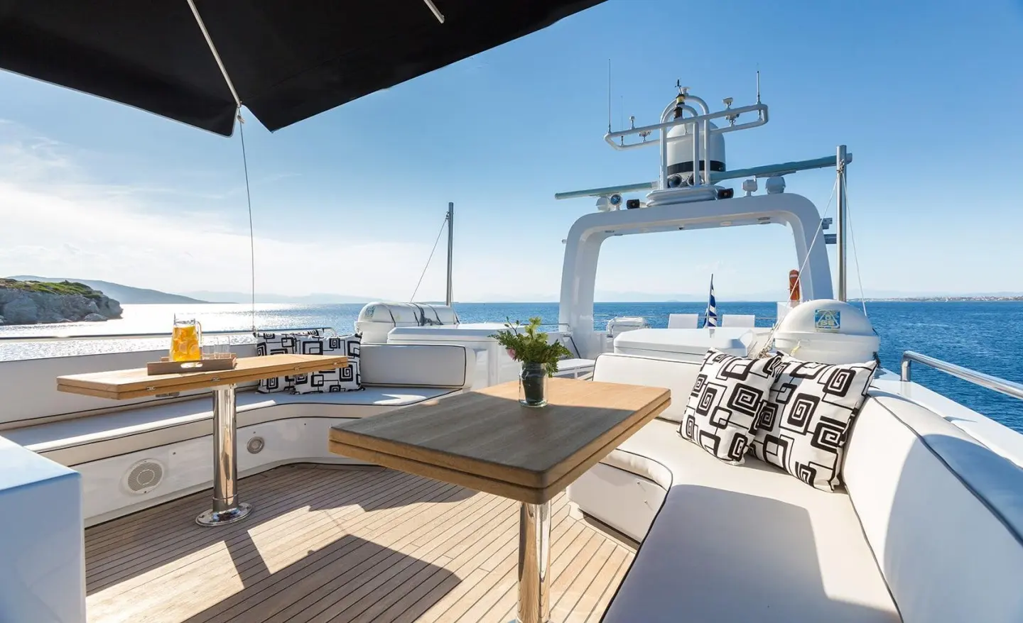 Aquarella motor yacht sundeck with seating, umbrella, and blue sea backdrop