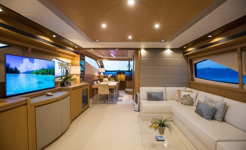 Luxurious Salt yacht interior: spacious saloon with white leather sofa, dining area, and large windows