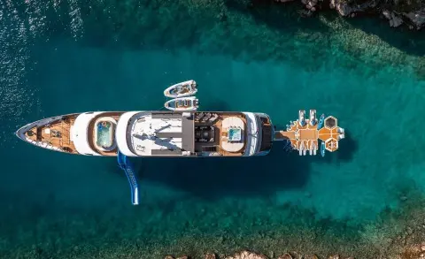 Aerial view of a white motor yacht named Freedom docked in clear blue water