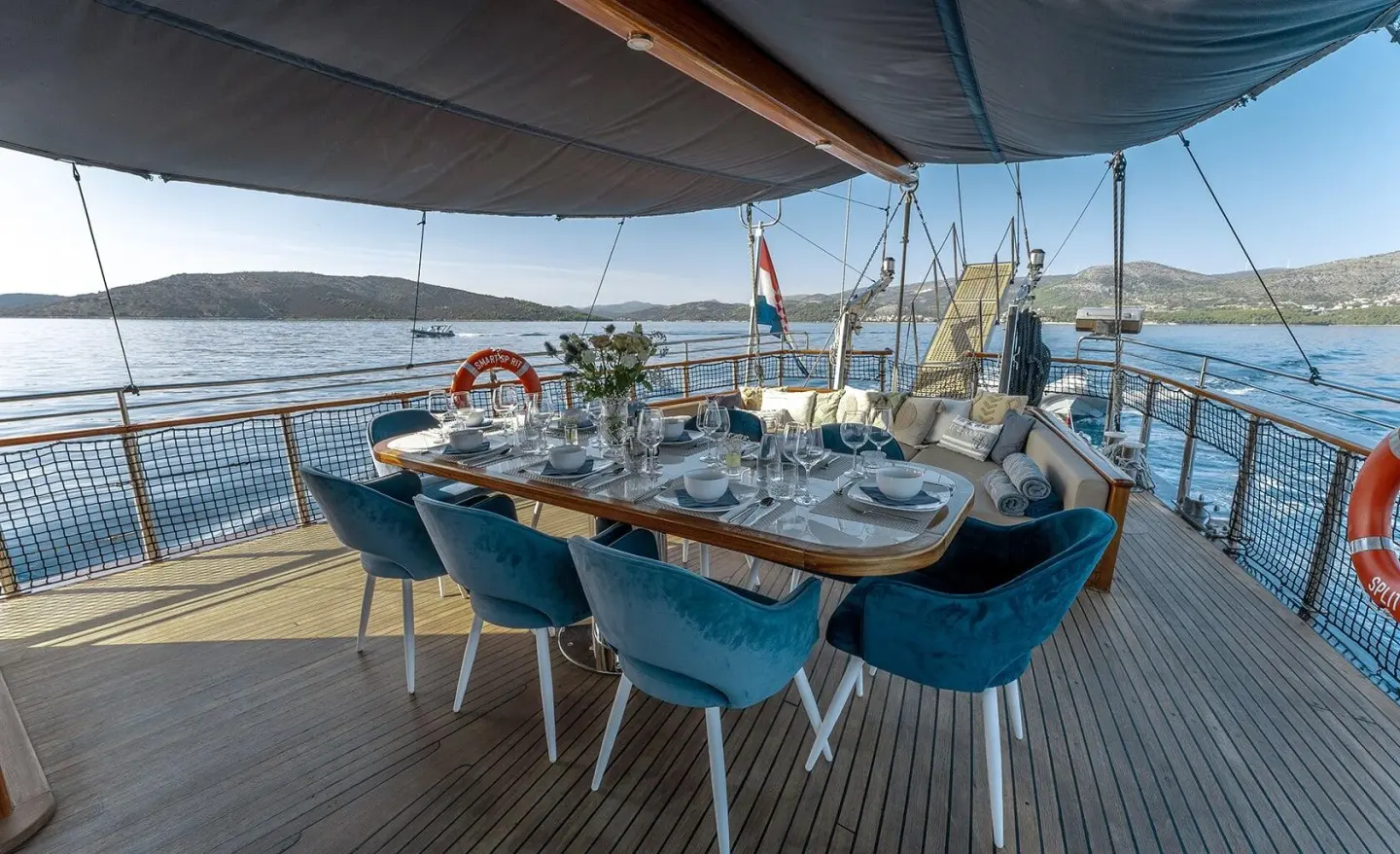 Luxury yacht Smart Spirit dining area on deck with table set under sunshade aboard