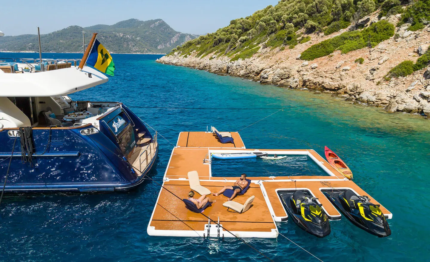 Amadea yacht deck scene at sunset with swimmers in turquoise water