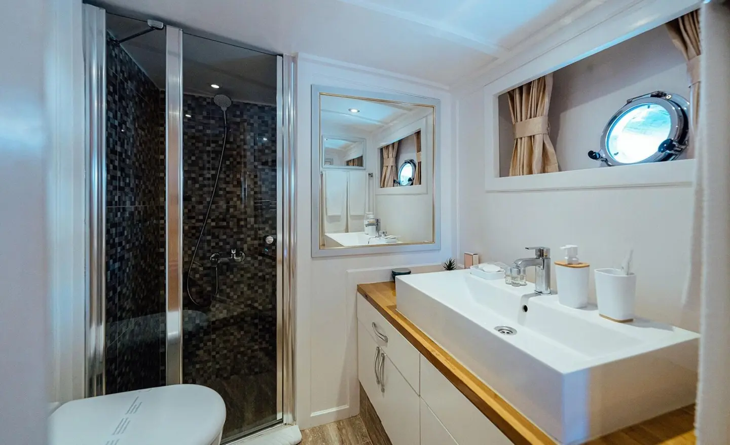 Maske yacht charter interior with sink, mirror, and bathroom vanity under warm lighting