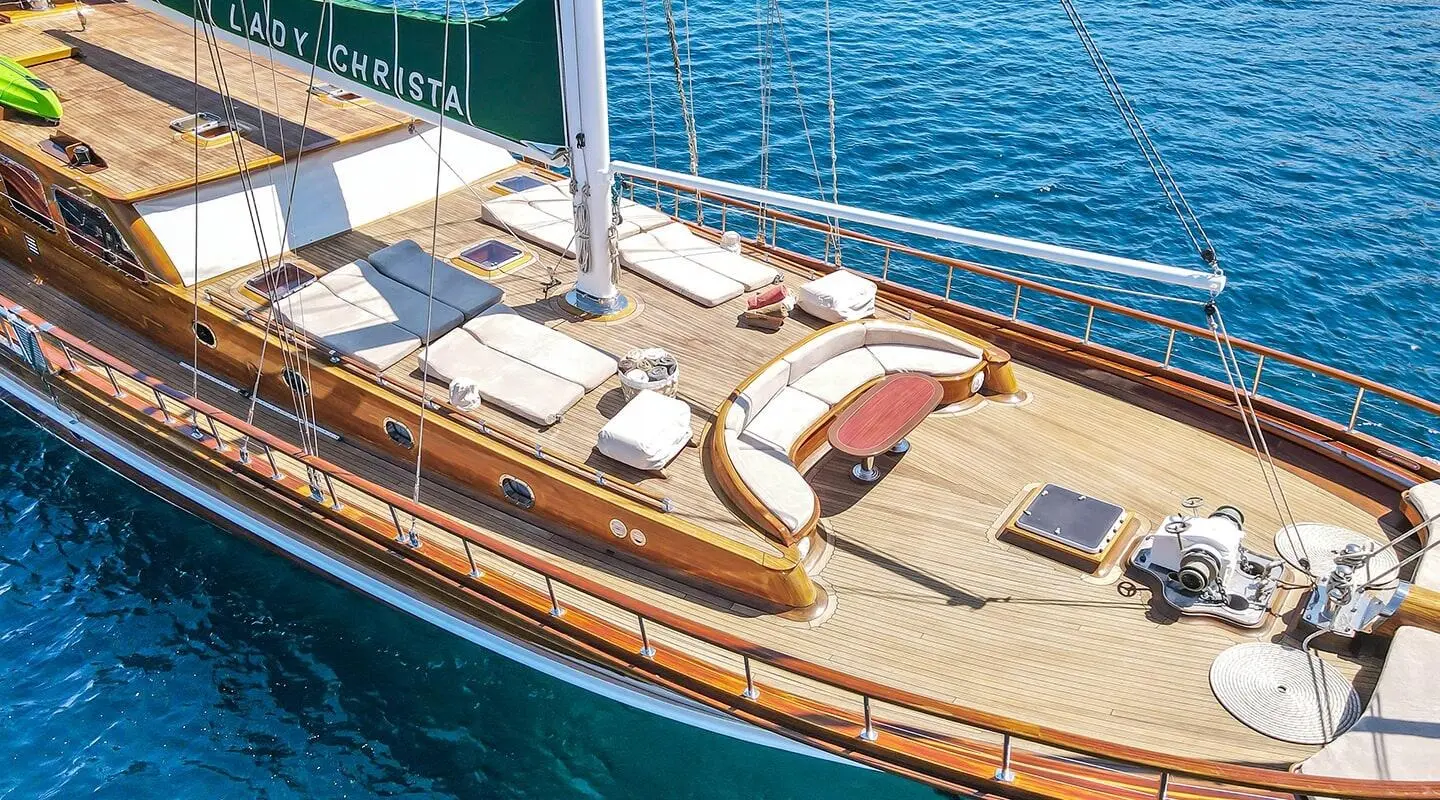 Yacht Lady Christa with seating and sun loungers on deck at sunset harbor