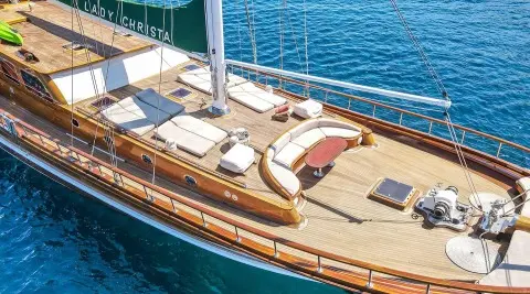Yacht Lady Christa with seating and sun loungers on deck at sunset harbor