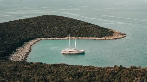 Maxita yacht anchored in a secluded cove with a calm turquoise bay
