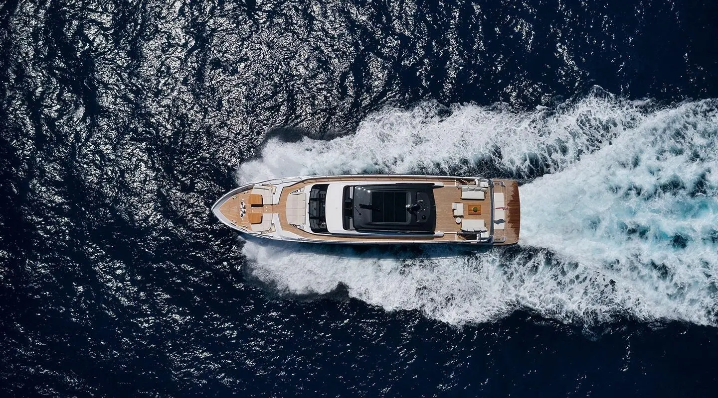 Aerial view of a sleek luxury motor yacht named Spica cruising through deep blue water