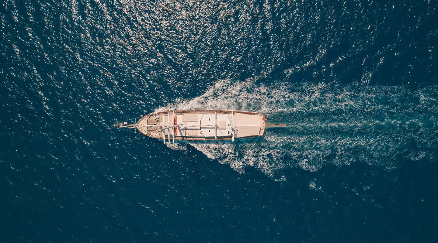Aerial view of Lycian Queen sailing across deep blue sea, white hull cutting through water