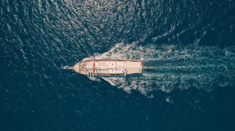 Aerial view of Lycian Queen sailing across deep blue sea, white hull cutting through water