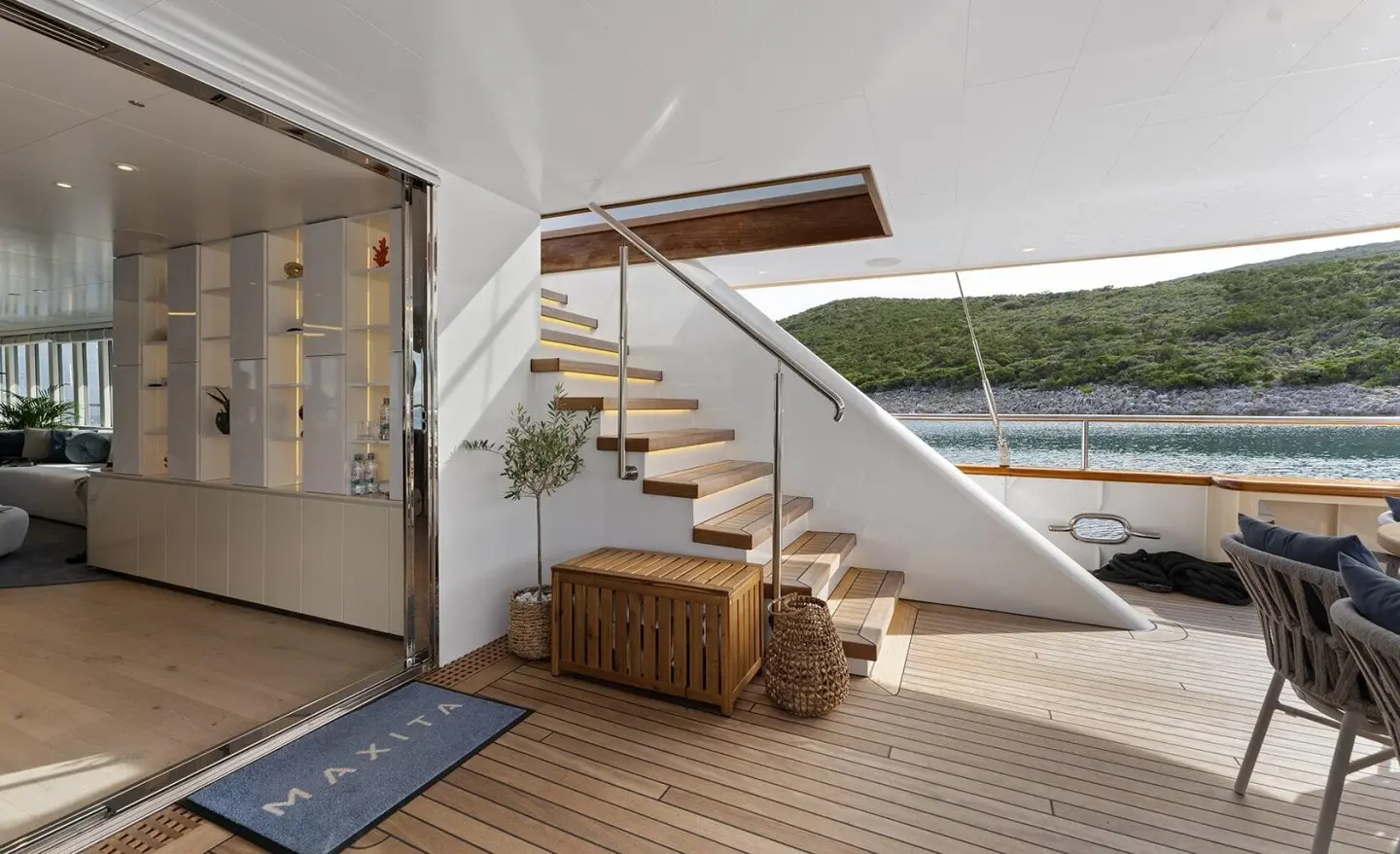 Yacht Maxita exterior deck area with wooden stairs leading to upper level