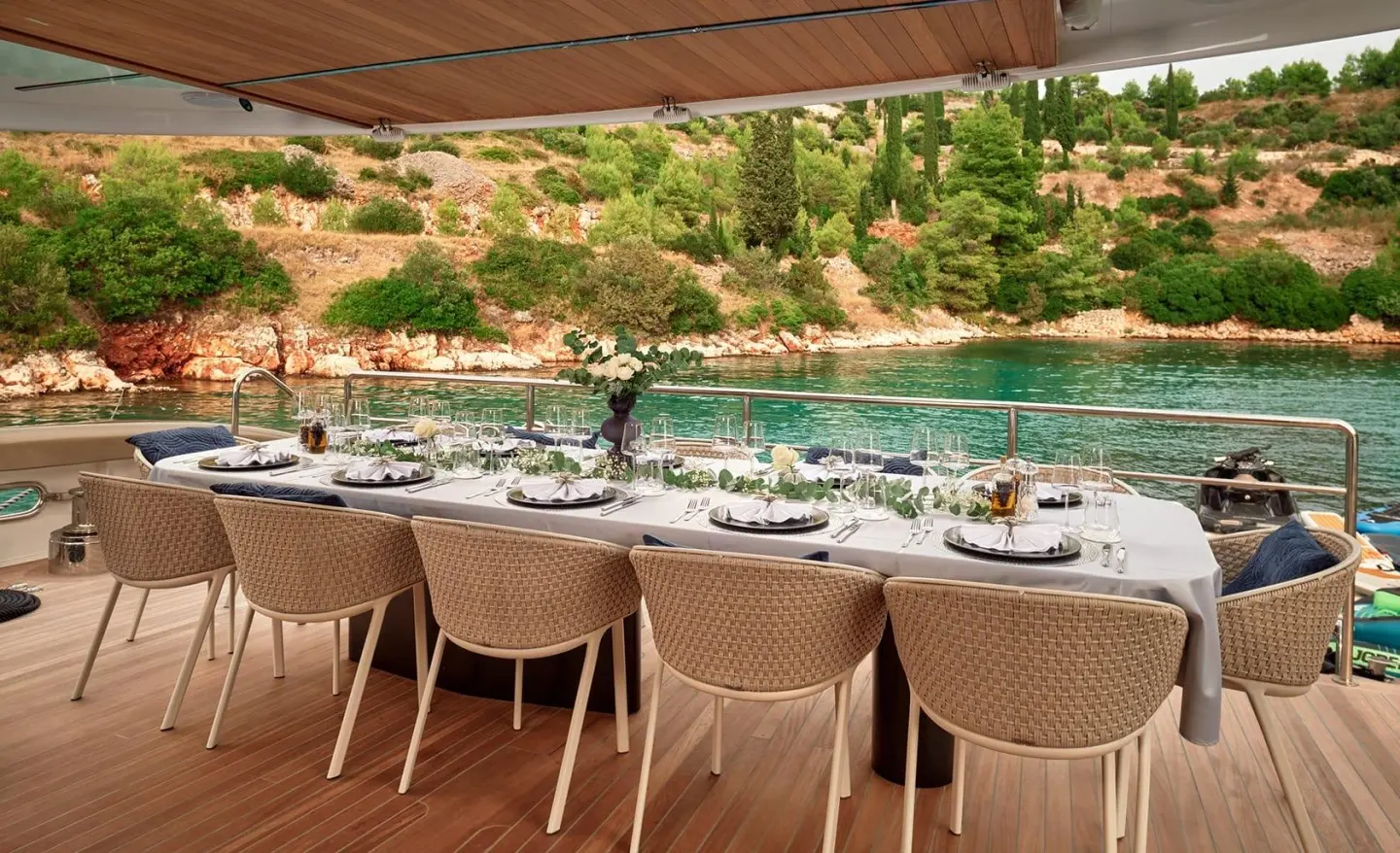 Anetta yacht dining area on deck facing calm turquoise sea at sunset