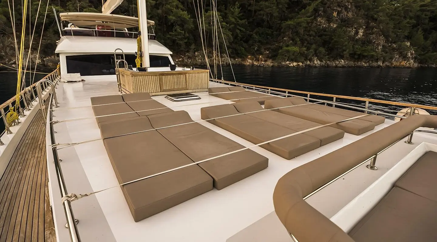 Sunset view from Belgin Sultan yacht deck with tan lounge cushions and calm sea