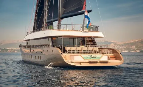 Back view of the Anetta motor yacht anchored in calm water with side deck and wake