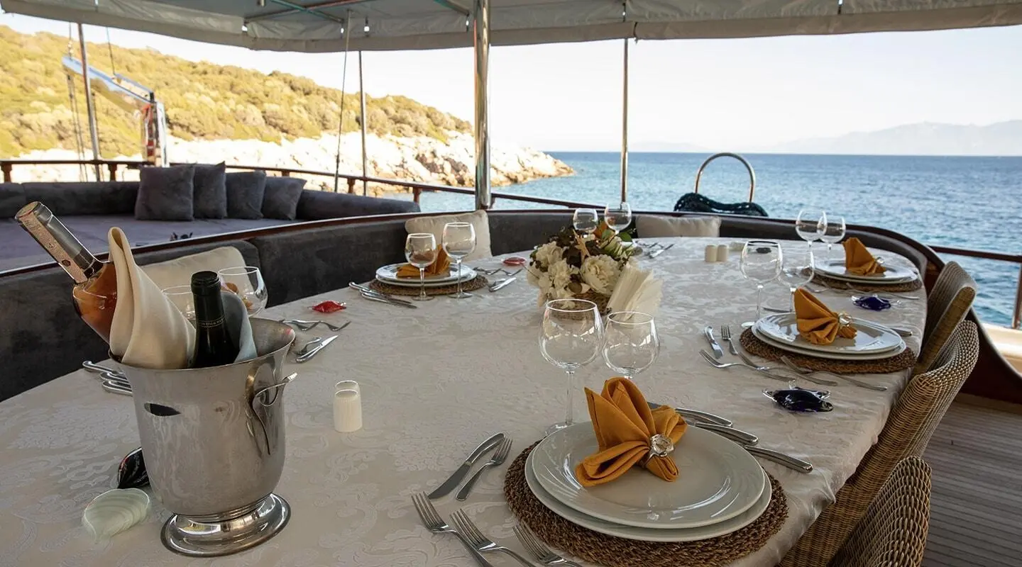 Arif Kaptan A yacht dining table set for al fresco marine charter with sea view
