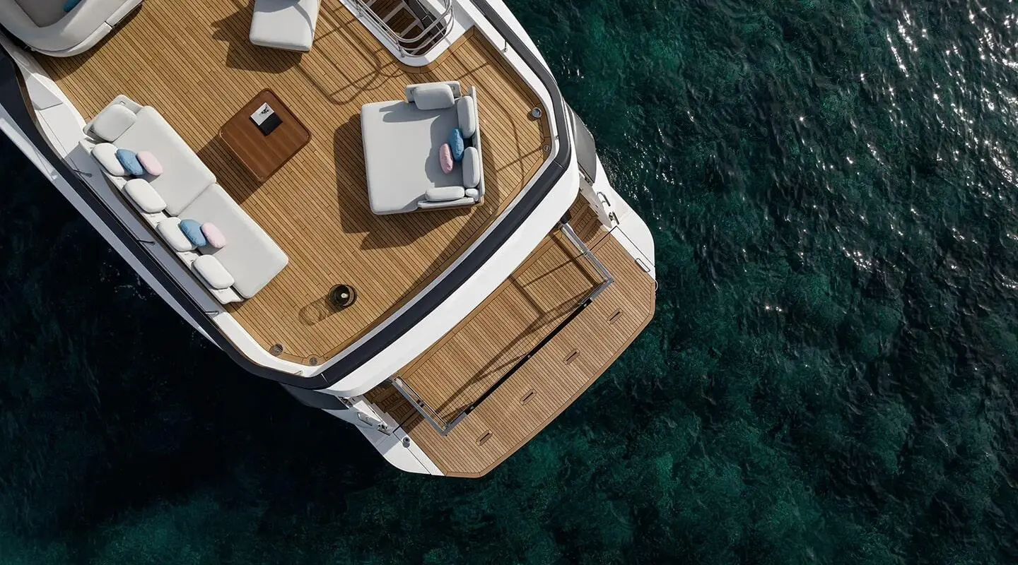 Top-down view of Viva II yacht docked in clear blue water, teak deck and seating