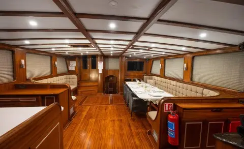 Interior of Estrella De Mar yacht with polished wooden decks and cozy seating.
