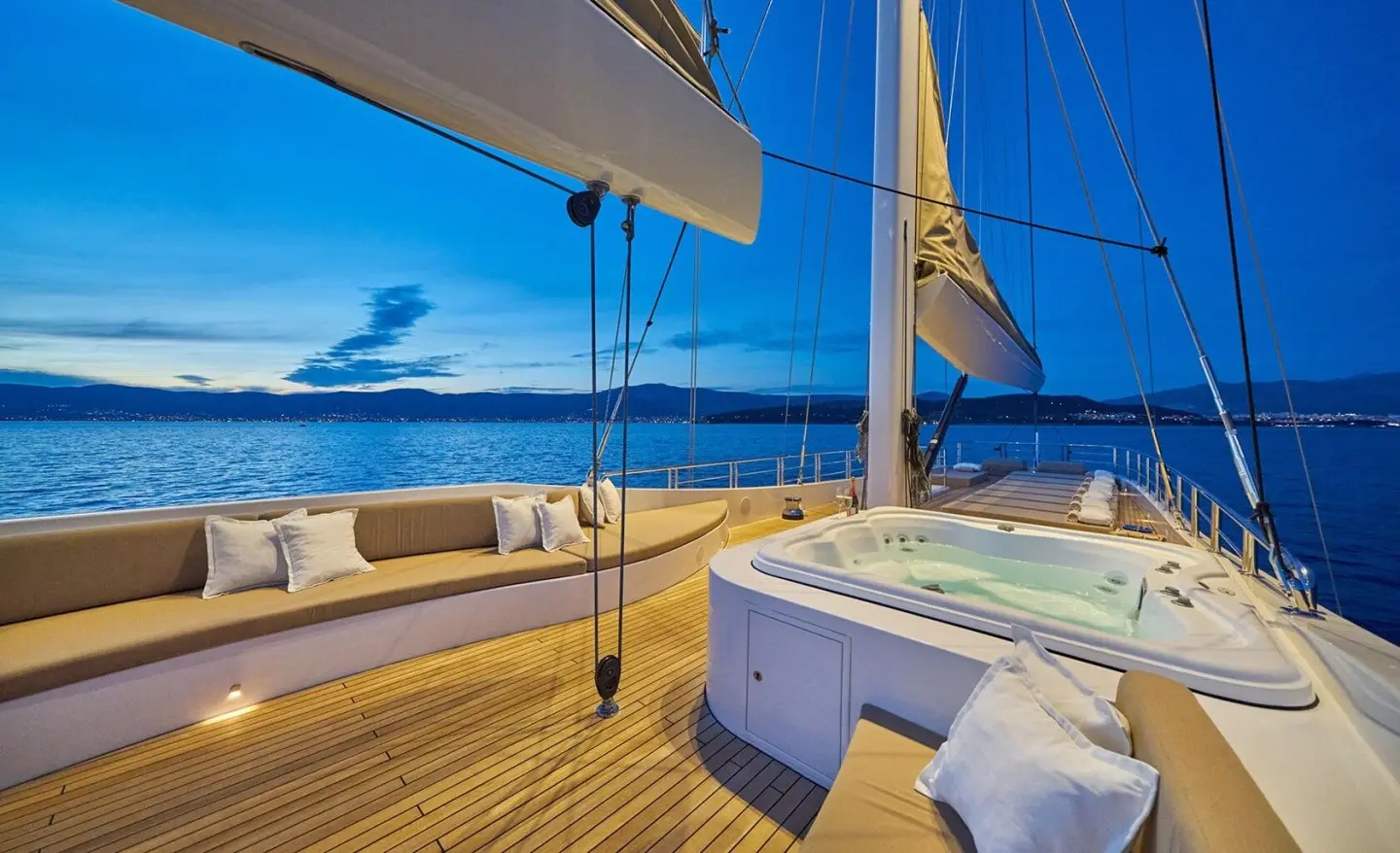 Upper deck of Acapella yacht: teak flooring, seating, shade awning, ocean view