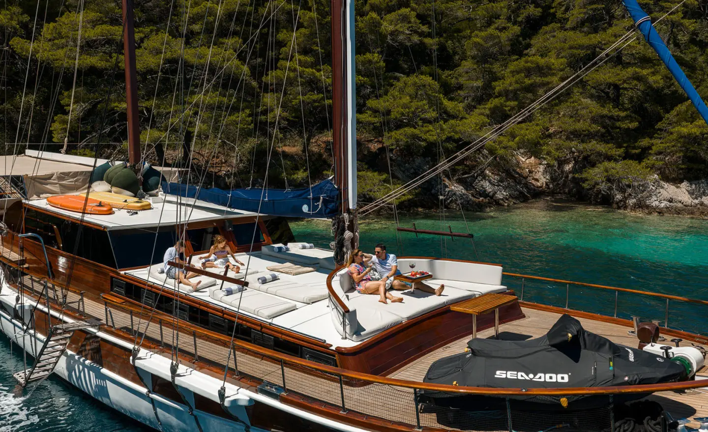 Eleganza yacht at anchor with wooden deck, side seating, and blue-green water