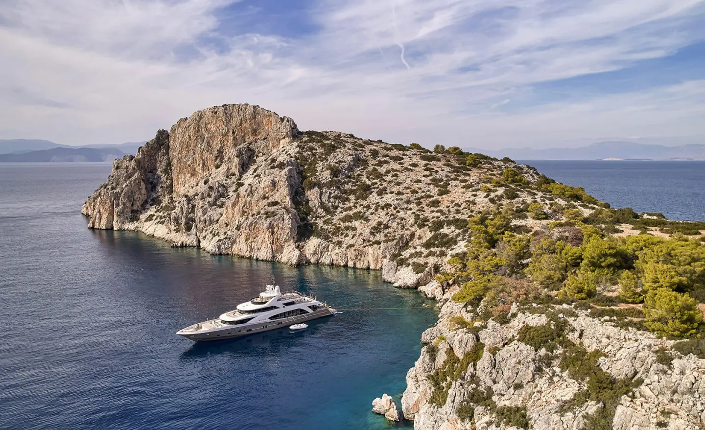 La Pellegrina 1 yacht anchored in a secluded cove beside rugged rocky cliffs