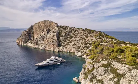 La Pellegrina 1 yacht anchored in a secluded cove beside rugged rocky cliffs