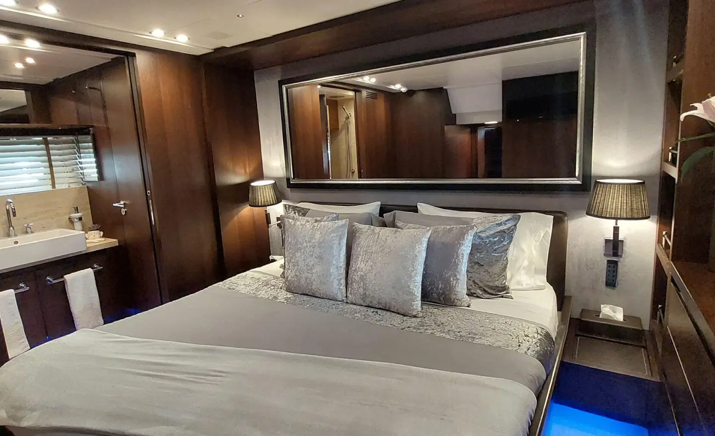 Miraval yacht interior: stylish cabin with bed, pillows, wood accents