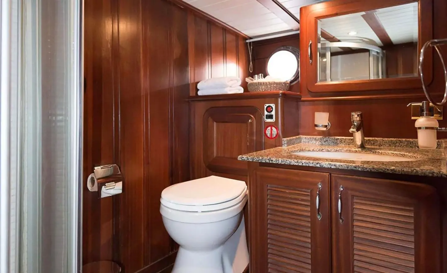 Luxurious yacht Primadonna interior with polished wooden cabinets, sink, and toilet