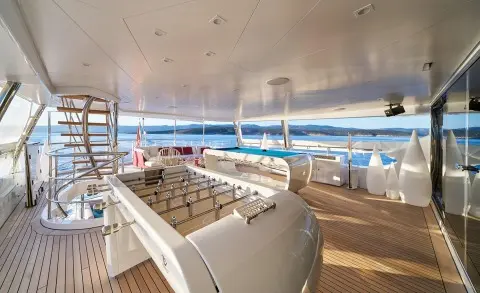 Deck seating area aboard Happy Me luxury yacht with white cushions and sun loungers