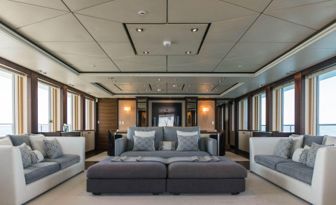 Alalya yacht interior living area with white and gray sofas, cushions, and large windows
