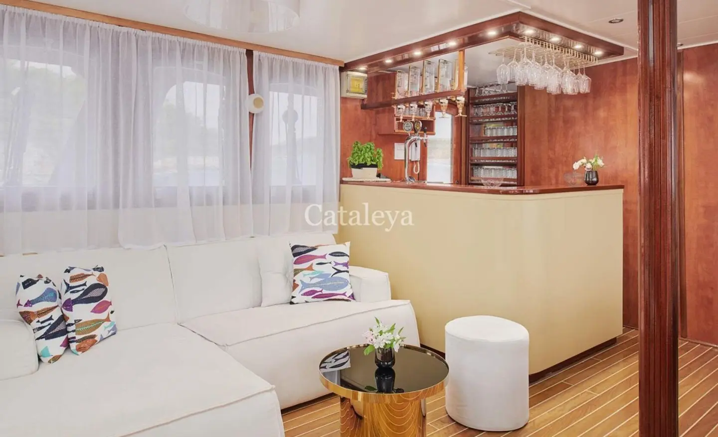 Bright wooden interior with light sofa and round glass-top coffee table by a bar