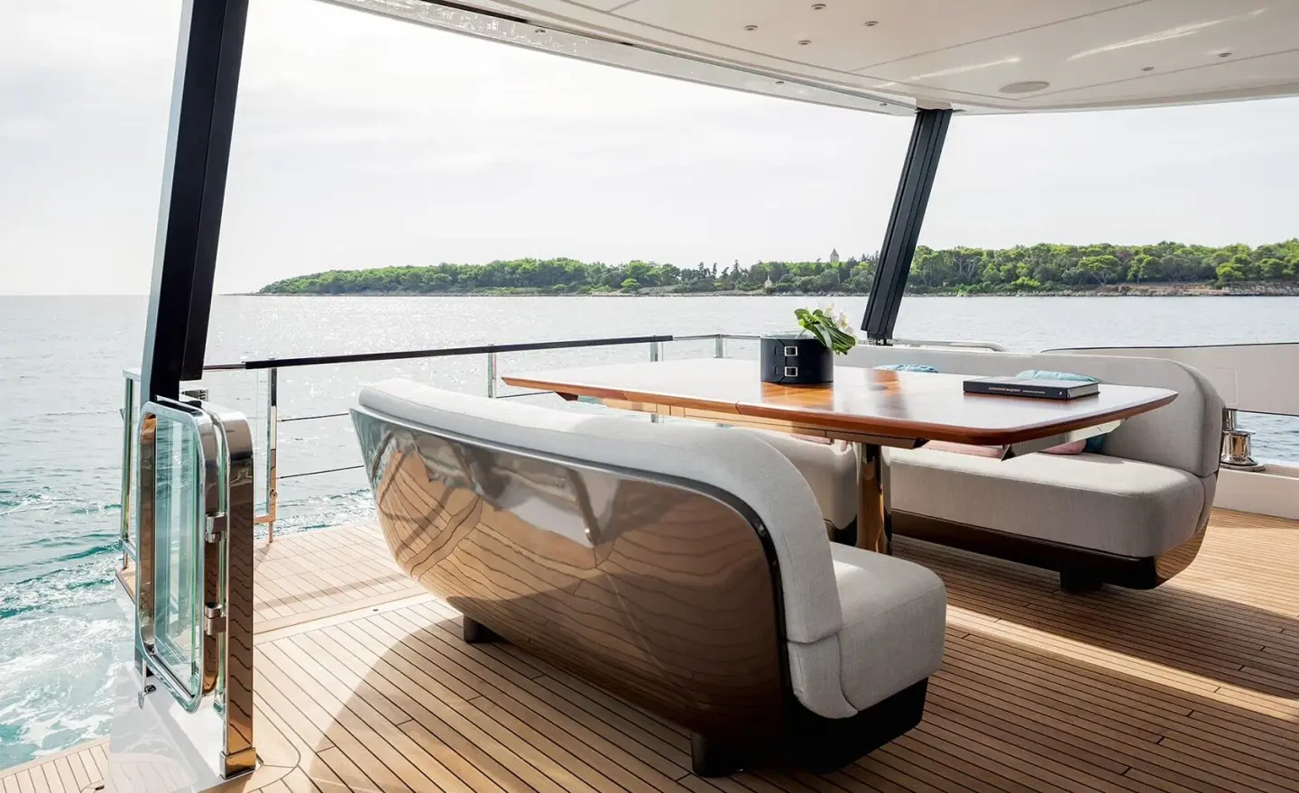 Viva II yacht deck seating area at sunset with dining table on wood deck