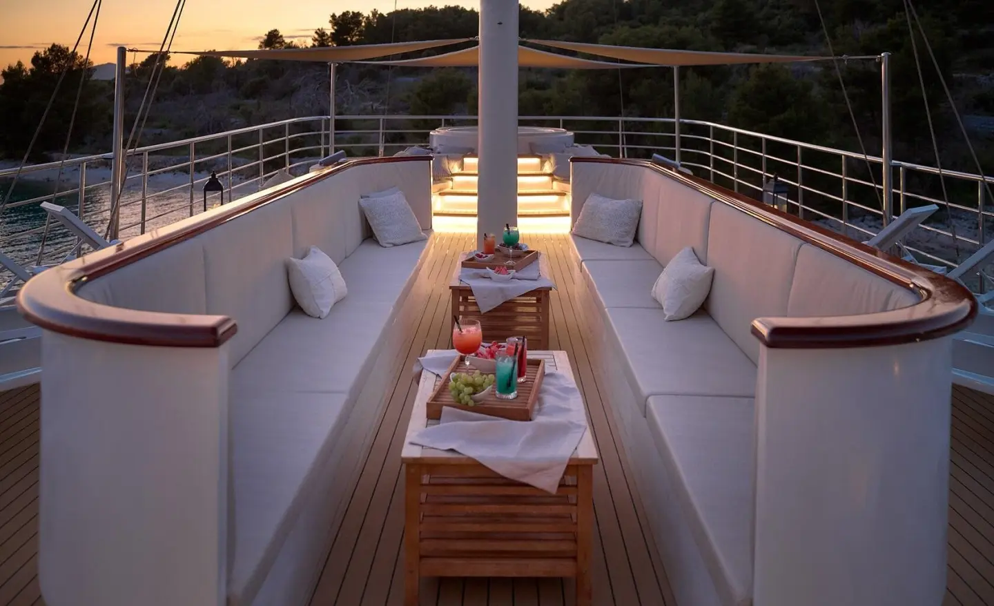 Bellezza motor yacht sun deck with seating, table, and snacks at dusk