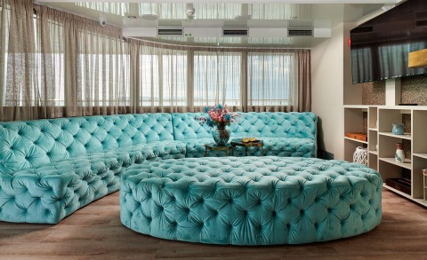 Ohana yacht lounge with turquoise tufted sectional seating and large windows