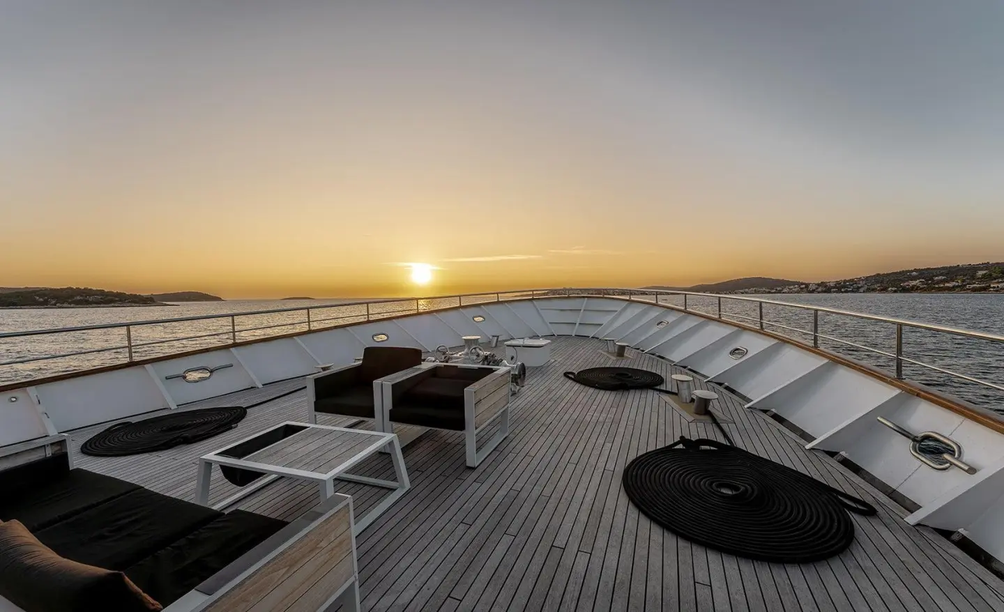 Sunset views from Karizma yacht deck with seating and railing silhouettes