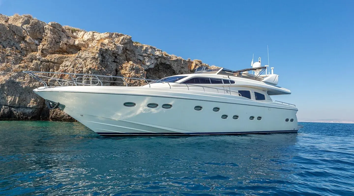 Amoraki luxury yacht anchored by rocky coastline with clear blue sea
