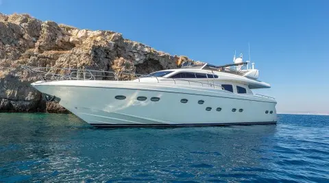 Amoraki luxury yacht anchored by rocky coastline with clear blue sea
