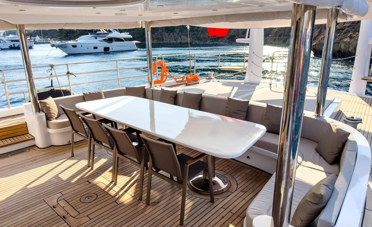 Angelo III yacht deck seating under shade with a white table and chairs
