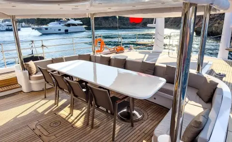 Angelo III yacht deck seating under shade with a white table and chairs