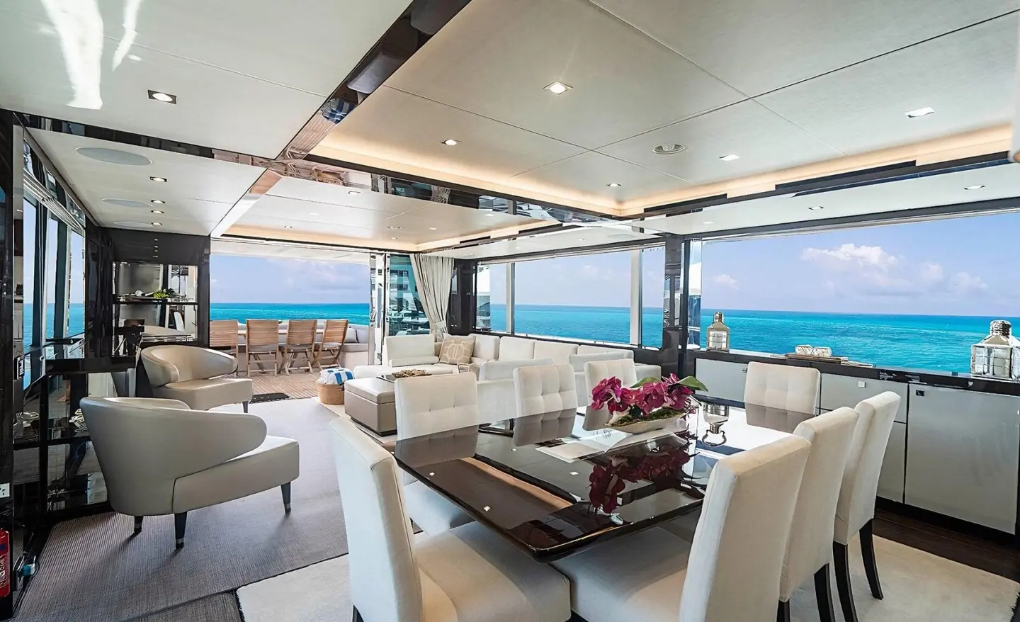 Quantum motor yacht saloon with white seating and open aft deck to sea view