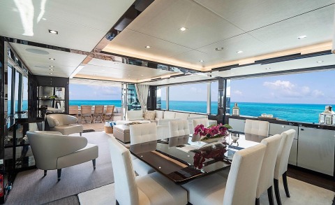Lux motor yacht Quantum interior with white seating and large windows overlooking the sea