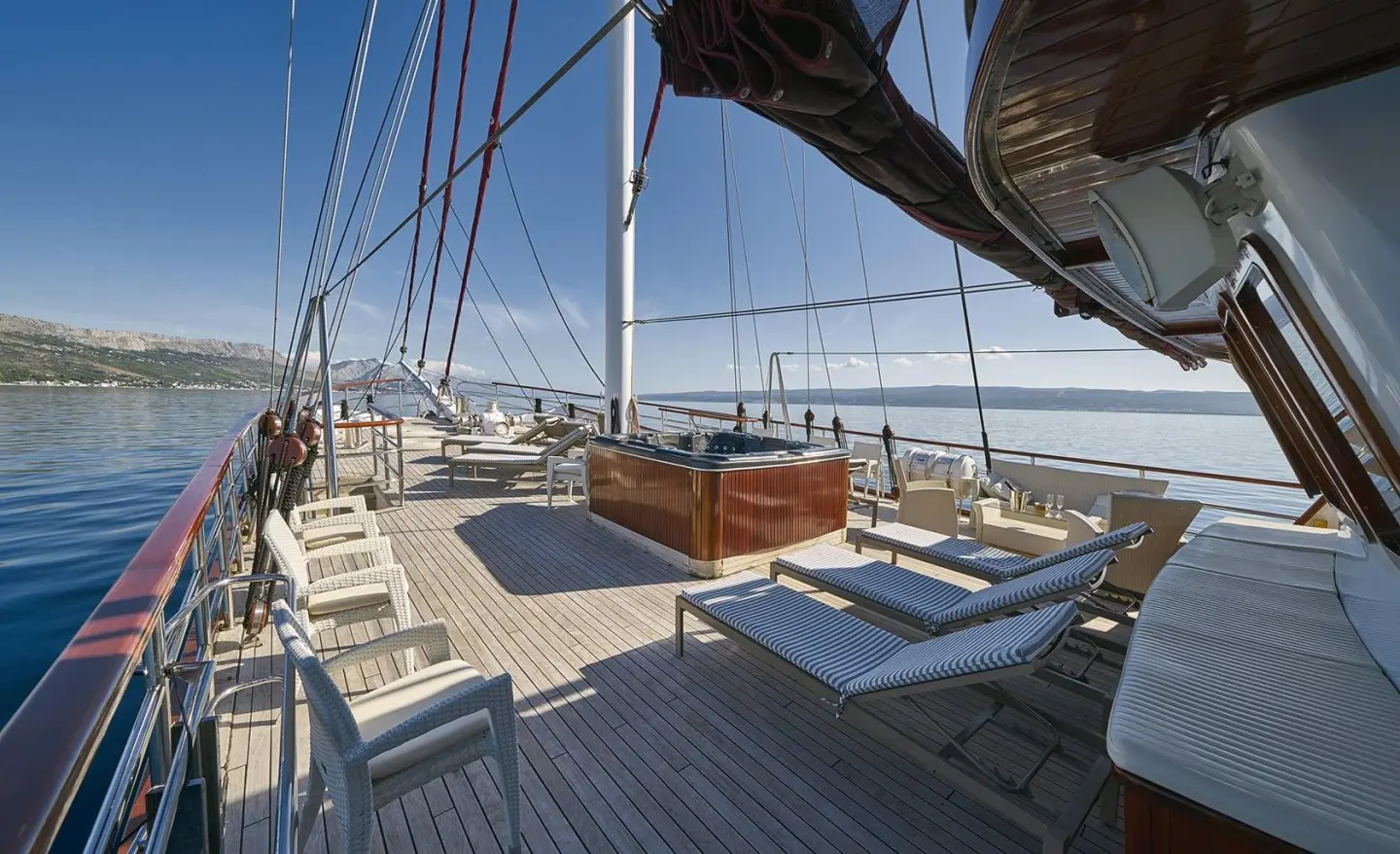 Deck seating area on Amorena yacht with sun loungers and ocean view