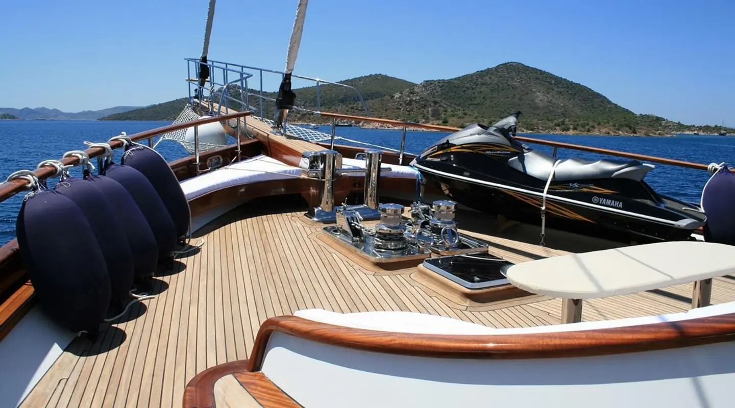 Kaya Guneri 5 yacht deck with wooden railings and water view at sunset