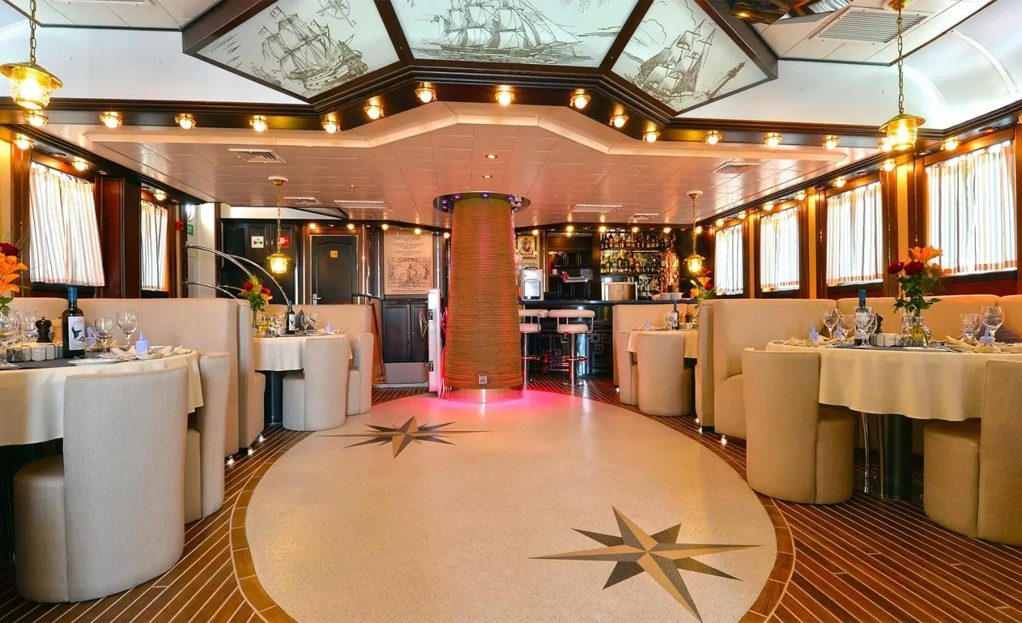 Luxurious yacht interior with polished wood, bar area, seating, and warm ambient lighting