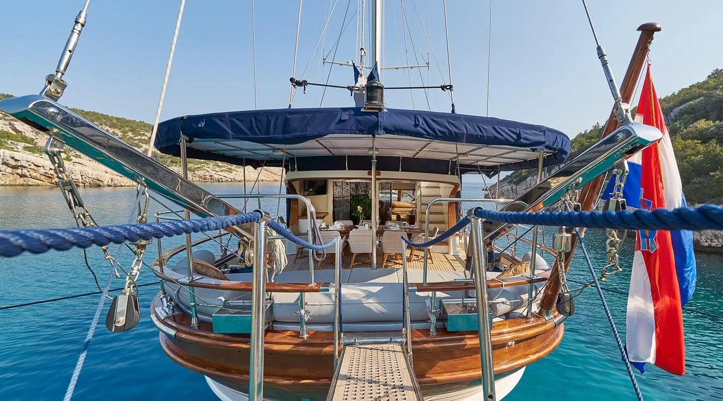 Front view of a wooden gulet yacht Lotus with blue awning and deck seating